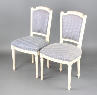 A pair of 19th Century white painted French salon chairs with upholstered seats and backs raised on turned and fluted supports 