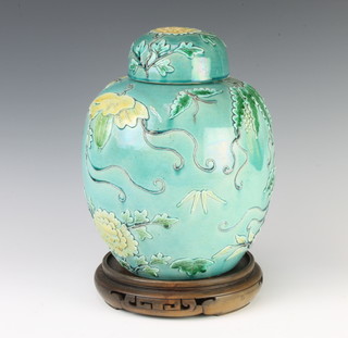 A Chinese turquoise ground ginger jar and cover decorated with insects amongst flowers 26cm and a pair of Chinese tapered oviform vases decorated with figures in gardens with domed lips and knop finials 20cm 