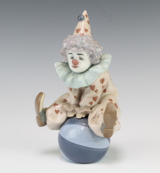 A Lladro figure of a clown sitting on a ball 5813 18cm 