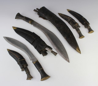 A Kukri with 35cm blade complete with scabbard and 2 skinning knives, together with 4 other Kukris 