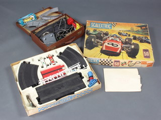 A Scalextric Grand Prix set 50 boxed complete with 2 cars, 1 hand controller and track, together with an attache case containing a Rovex Ltd Scalextric car, power controller, 2 hand controls and a small quantity of track 