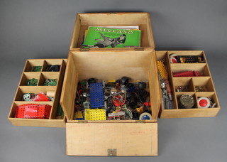 A quantity of green and red Meccano contained in a plywood box with hinged lid, fall front and iron drop handles 