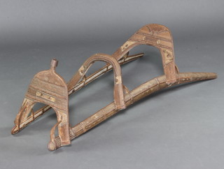 A wooden and metal mounted camel saddle 30cm h x 49cm w x 52cm d 