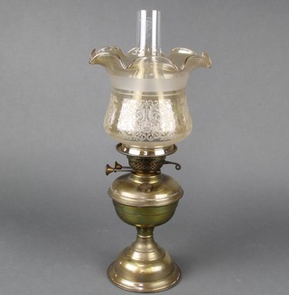 A brassed oil lamp with etched glass shade and clear glass chimney 