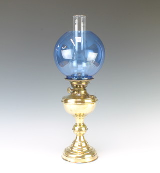 A brass oil lamp with blue tinted glass shade and clear glass chimney 55cm x 16cm 