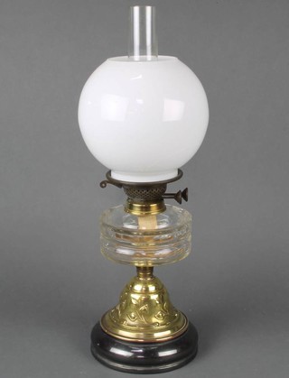 An Art Nouveau circular panel cut glass oil lamp reservoir raised on an embossed circular spreading foot with opaque glass shade (cracked) and chimney 53cm x 16cm together with a decorative table lamp formed from a cut glass brandy barrel marked Special Brandy raised on a wooden base  44cm x 25cm (some chips to rim) 