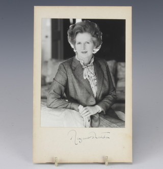 A black and white portrait photograph of Margaret Thatcher seated, signed in the margin by Margaret Thatcher 16cm x 12cm 