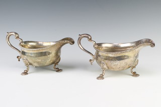 A pair of George II silver sauce boats with beaded rim and S scroll handles with shell knees on shell feet, bearing armorials, London 1754, 806 grams