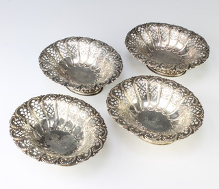 A set of 4 Victorian pierced and repousse silver bon bon dishes with floral decoration, having armorials, Sheffield 1894, 464 grams 