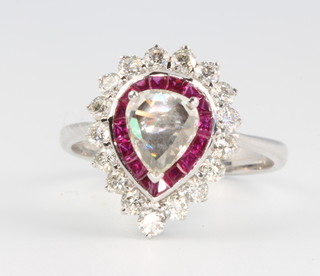 An 18ct white gold pear shaped diamond and ruby ring, the centre stone 0.56ct surrounded by Princess cut rubies 0.78ct and brilliant cut diamonds 0.56ct size N 
