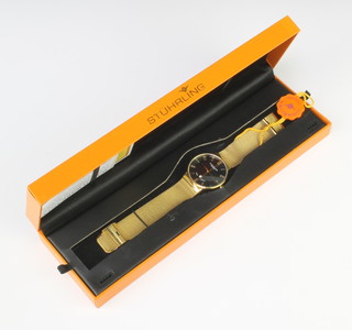 A gentleman's gilt case Stuhrling black dial wristwatch with calendar dial on a gilt bracelet, boxed