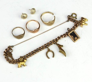 Three gold charms on a gilt bracelet, 3 gold rings and a pair of earrings 