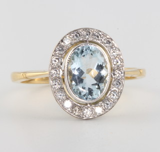 An 18ct yellow gold oval aquamarine and diamond cluster ring size O 1/2