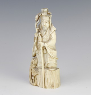 A late 19th Century carved ivory figure of a gentleman on a rocky outcrop 13cm 