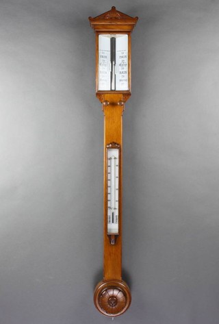A Victorian mercury stick barometer contained in a carved light oak case 