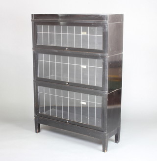 An ebonised Globe Wernicke 3 tier bookcase enclosed by lead glazed panelled doors raised on square tapered supports 125cm h x 87cm w x 29cm d 