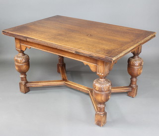 An oak draw leaf dining table, raised on carved cup and cover supports with Y shaped stretcher  77cm h x 91cm w x 127cm l when closed x 211cm when extended 