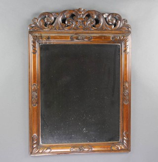 An 18th Century style plate wall mirror contained in a carved pierced oak cushion shaped frame 68cm x 55cm 