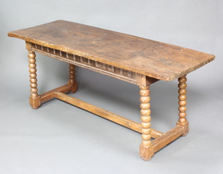 A 17th/18th Century rectangular elm refectory table with carved apron raised on bobbin turned supports with H framed stretcher 76cm h x 184cm l x 69cm w 