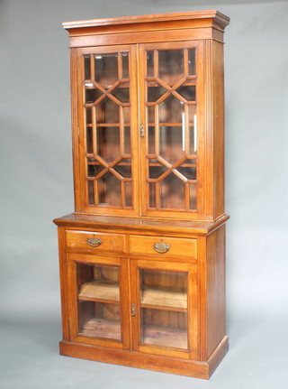 A Victorian mahogany display cabinet on cabinet, the upper section with moulded cornice, the adjustable shelves enclosed by astragal bevelled panel doors, the base fitted 2 drawers above a double cupboard enclosed by bevelled panelled doors, raised on a platform base 228cm h x 106cm w x 50cm  