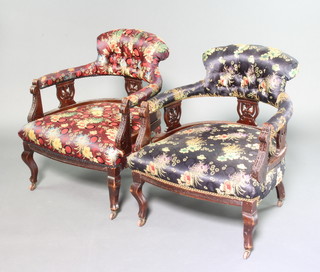 A pair of Edwardian carved mahogany show frame armchairs upholstered in Chinese style silk buttoned material, raised on cabriole supports 
