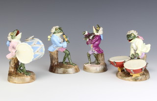 A set of 4 Thuringia porcelain figures of frog musicians comprising a base drummer, a flutist, a timpani drummer and violinist, raised on circular bases, impressed and printed marks 