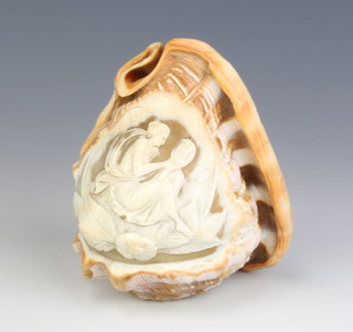 A carved and polished abalone shell carved a figure of a seated lady - the end cut to reveal an aperture 5cm x 11cm x 9cm 