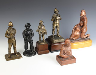 A bronzed figure of a 19th Century fireman rescuing a lady 22cm x 23cm x 15cm together with three bronze figures of standing firemen in breathing apparatus, a coal figure of a standing fireman and 1 other