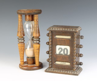 A perpetual calendar contained in an oak case 15cm x 12cm x 7cm together with an hour glass in a turned bobbin 21cm x 9cm 