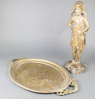 A brass fireside companion set in the form of a standing town crier 55cm x 20cm x 21cm together with an oval Indian engraved brass twin handled tea tray 69cm x 40cm 