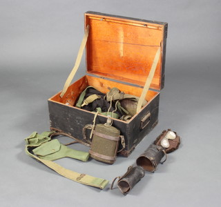 A military style instrument box containing a WWII webbing belt and holster, pair of webbing gaiters, water bottle, goggles and other items and a small section of blackout curtains 