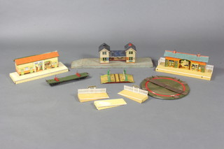 A Bing O gauge station, a Hornby tinplate station, a level crossing and a Meccano turn table 