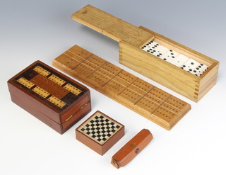 A part carved red and white ivory miniature chess set (there are 2 extra red pawns, the whites are missing 5 pawns, the castle and the rook are F) contained in a wooden box together with 2 wooden cribbage boards, a set of dominos and a dice set 
