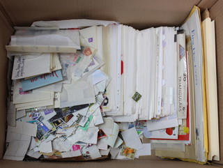 A box containing a collection of first day covers and loose world stamps 