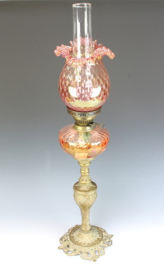 A Rococo style amber glass oil lamp reservoir raised on a pierced gilt metal base, having a clear glass chimney 33cm h x 19cm diam. 
