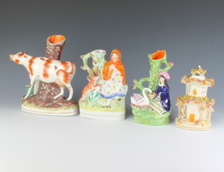 A Staffordshire spill vase in the form of a standing cow 24cm, a ditto of Little Red Riding Hood 20cm, 1 other of a lady with a swan 20cm and a 2 storey cottage pastel burner 17cm 