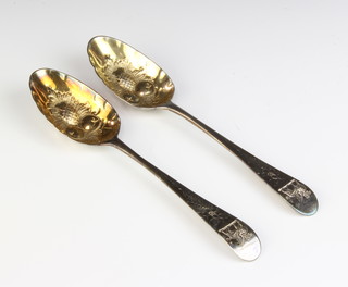 A pair of George III silver berry spoons with chased armorial 132 grams 