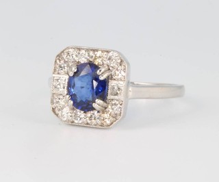 An 18ct white gold Art Deco style sapphire and diamond cluster ring, the oval cut stone surrounded by brilliant cut diamonds size M 1/2