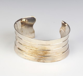 A silver bangle with ribbed decoration 67 grams
