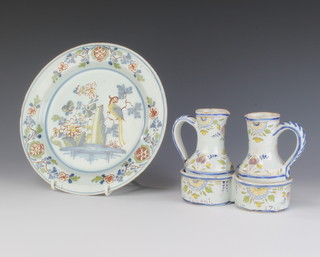 An 18th Century English Delft plate decorated with an exotic bird amongst trees 23cm and a Continental Delft pair of jugs in a 2 division receptacle 15cm 
