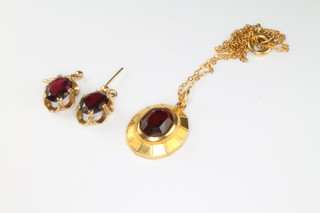 A suite of 9ct yellow gold garnet set jewellery comprising pendant on chain and earrings
