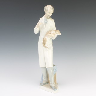 A Lladro figure of a veterinary surgeon holding a dog by the sculptor Salvatore Furio 33cm 