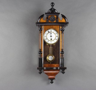A Vienna style regulator with 11cm enamelled dial and Roman numerals, grid iron pendulum and contained in a carved walnut case 
