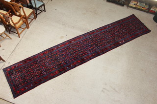 A Persian red and blue ground Behbahan runner with floral ground within multi-row border 537cm x 100cm 