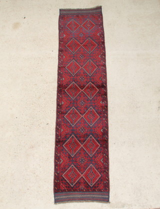 A blue and red ground Meshwani runner with 14 diamonds to the centre within a multi row border 256cm x 61cm