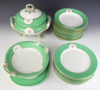 A Victorian porcelain dinner service with green and gilt rim enclosing an armorial comprising a tureen and lid, a tazza, 2 rounded rectangular meat plates, 13 soup bowls, 9 dinner plates