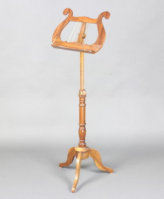 A 19th Century style adjustable mahogany music stand, the upper section in the form of a lyre, raised on turned pillar and tripod supports 120cm h x 43cm w 