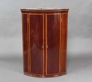 A Georgian inlaid mahogany bow front corner cabinet, fitted shelves enclosed by inlaid panelled doors 104cm h x 72cm w x 47cm d