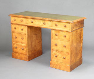 A Victorian satinwood kneehole desk with green inset writing surface fitted 1 long drawer flanked by 8 short drawers raised on a platform base 76cm h x 123cm w x 46cm d 