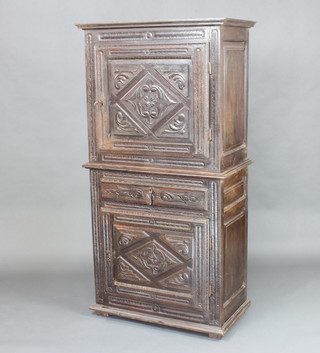 An 18th Century Continental carved oak cabinet on cabinet, the upper section with moulded cornice fitted a shelf enclosed by a panelled door, the base fitted 1 long drawer above a cupboard enclosed by a panelled door 165cm h x 85cm w x 47cm d 